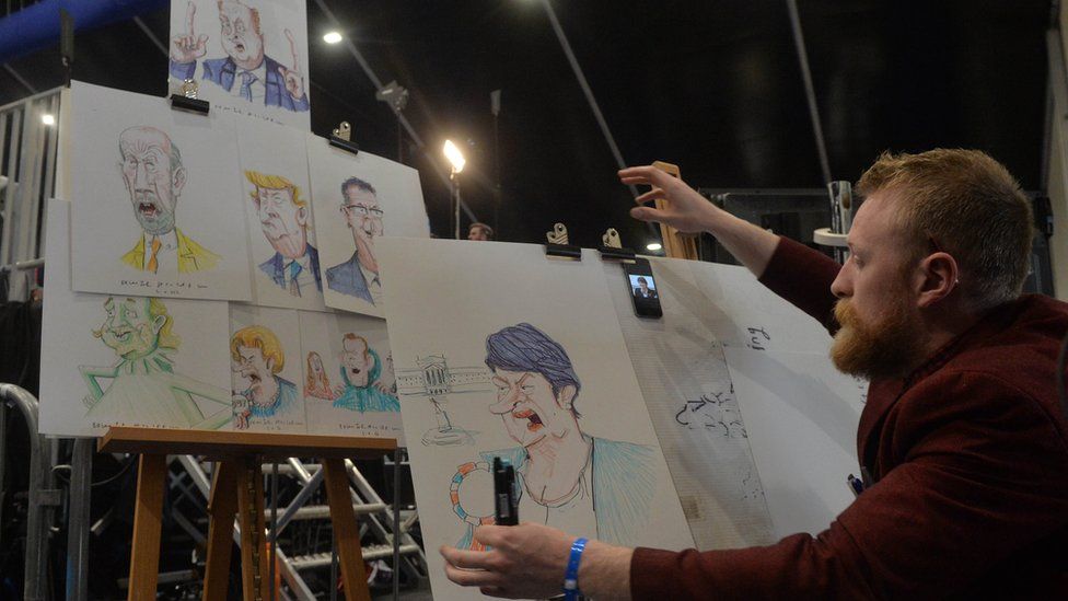 Cartoonist Brian Spencer draws political figures at the Belfast count centre