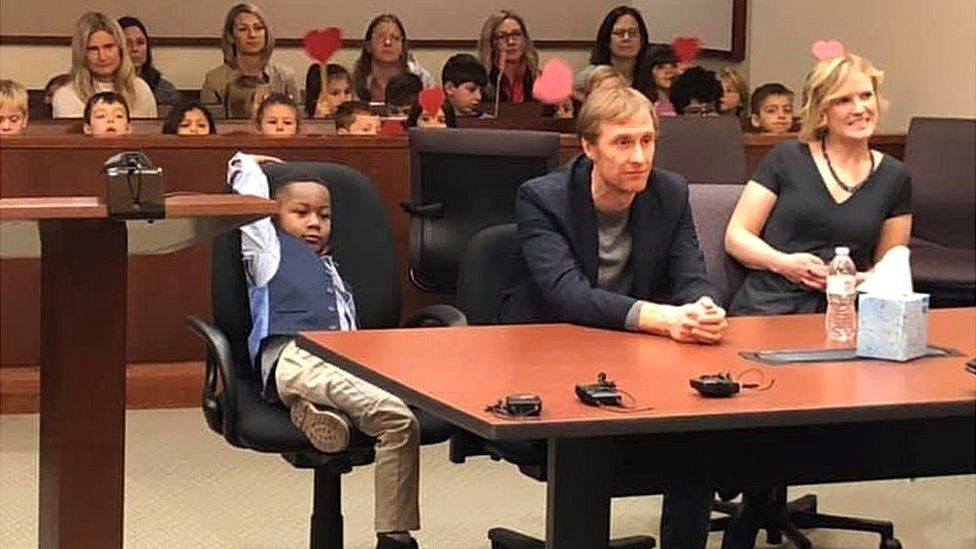 A picture shared by Kent County, Michigan's Facebook page shows a little boy named Michael being formally adopted in court, watched by his Kindergarten classmates