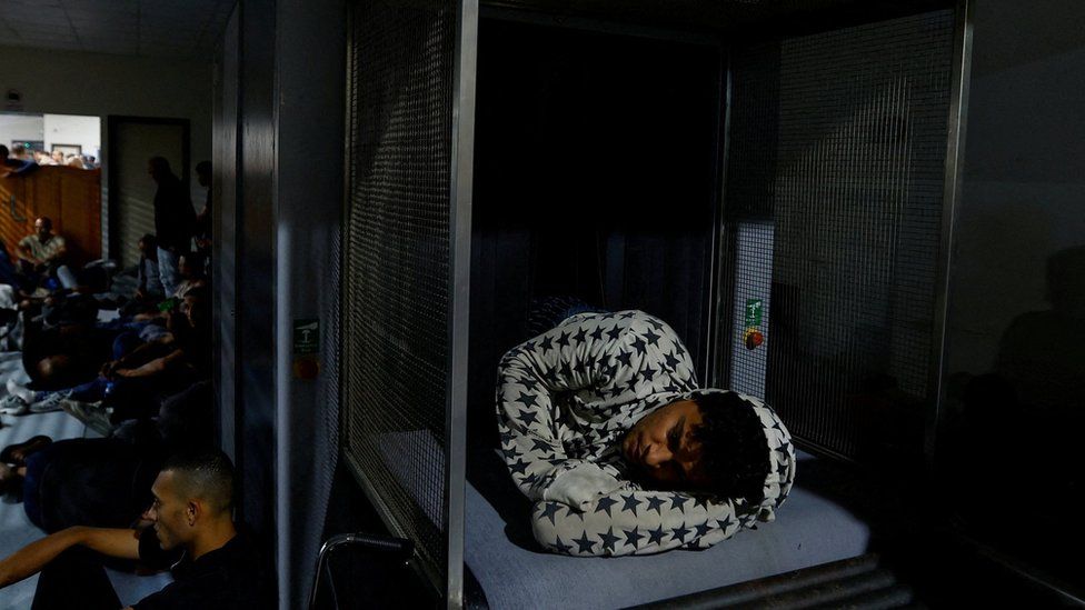 Палестинский рабочий спит внутри сканирующего устройства на контрольно-пропускном пункте Эрез между сектором Газа и Израилем, ожидая его открытия (28 сентября 2023 г.)