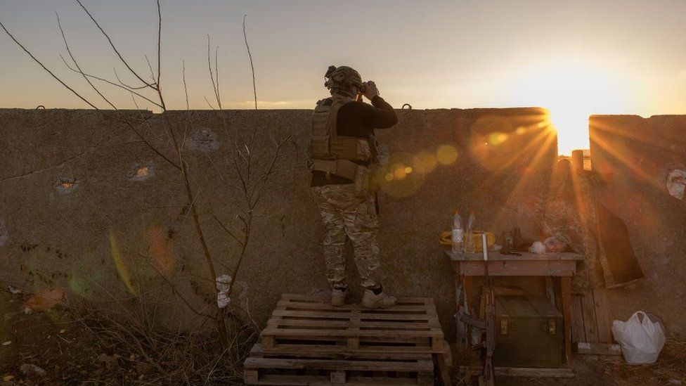 A Ukrainian serviceman of the 123rd Territorial Defense Brigade watches an area of the Dnipro River