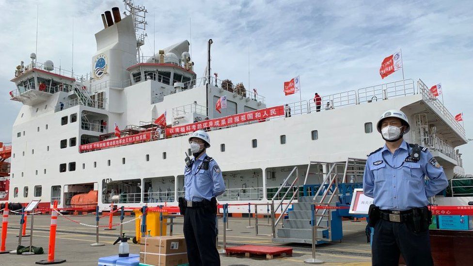 Foto von zwei Wachleuten vor dem Eisbrecher Xuelong 2 in Shanghai, China, nachdem dieser nach einer fünfmonatigen Expedition eingetroffen war.