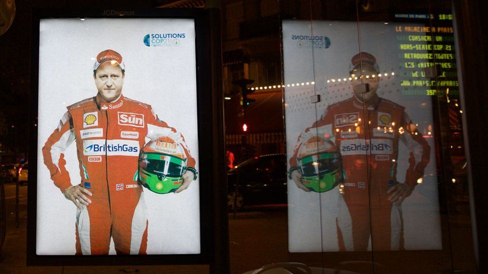 A poster featuring British Prime Minister David Cameron shows him in Formula 1 gear