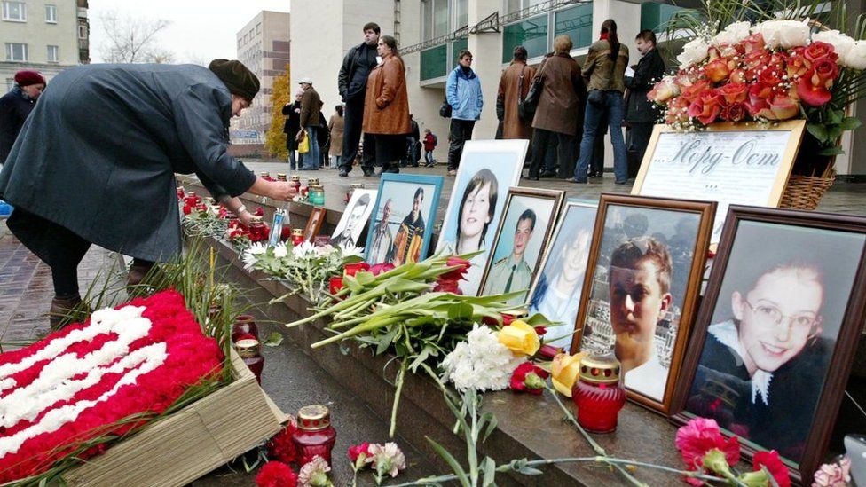 A woman puts a portrait of her relative in front of the Dubrovka theatre in Moscow in 2004, where Chechen militants took hundreds hostage in 2002