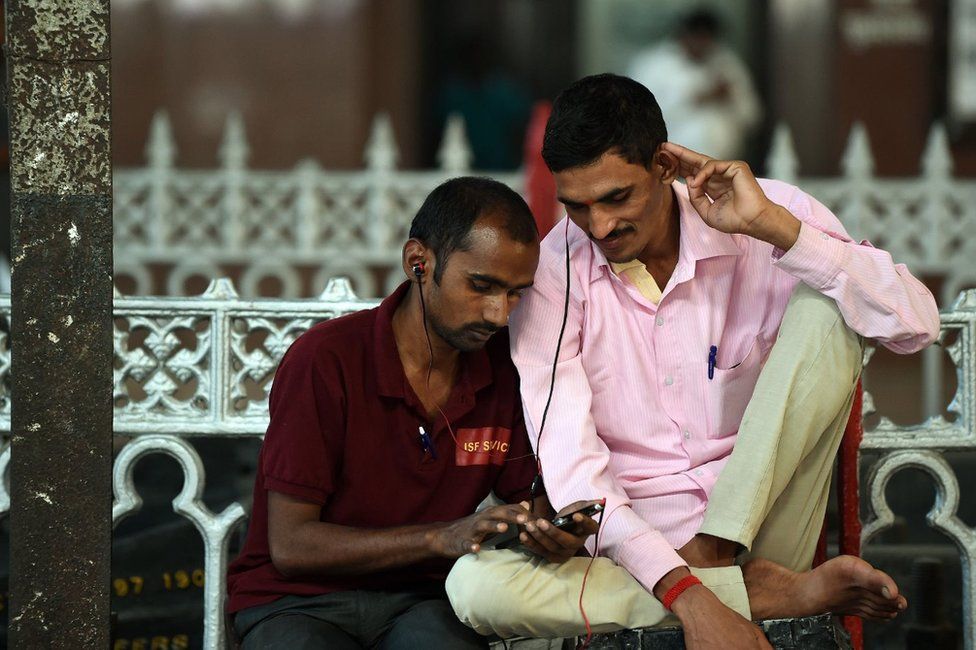 Indian commuters use their smartphones following the introduction of a new free Wi-Fi Internet service in Mumbai's central railway station on January 22, 2016.