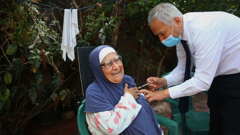 Dr Jamal Rifi administers a second dose of the Pfizer vaccine to a member of the Alameddine family at home on October 03, 2021 in Sydney
