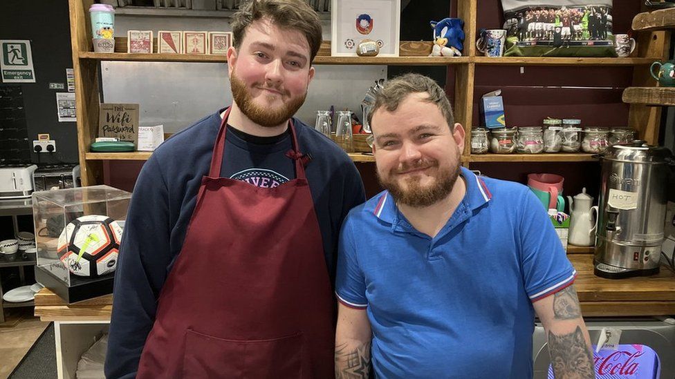 Cafe Track employees, Jack and Alfie, behind the coffee counter.