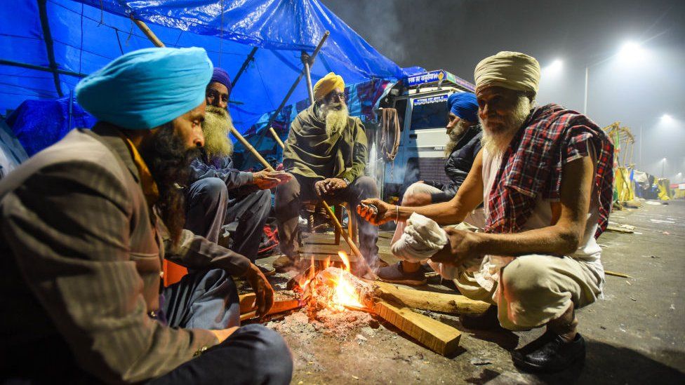 Farmer warm themselves around a bonfire at Ghazipur on January 28, 2021