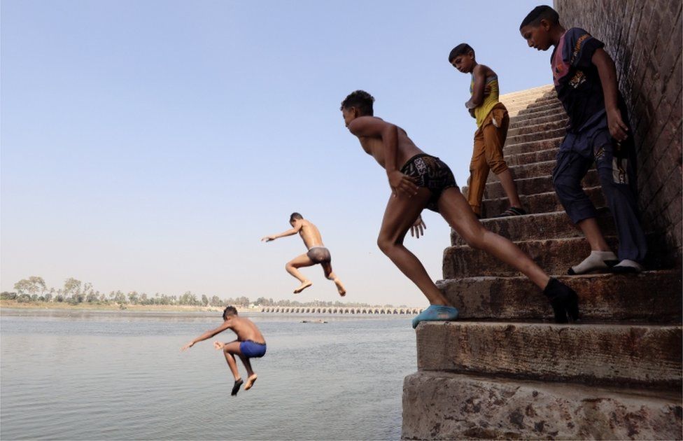 Boys jump from stairs into the river, in Cairo.