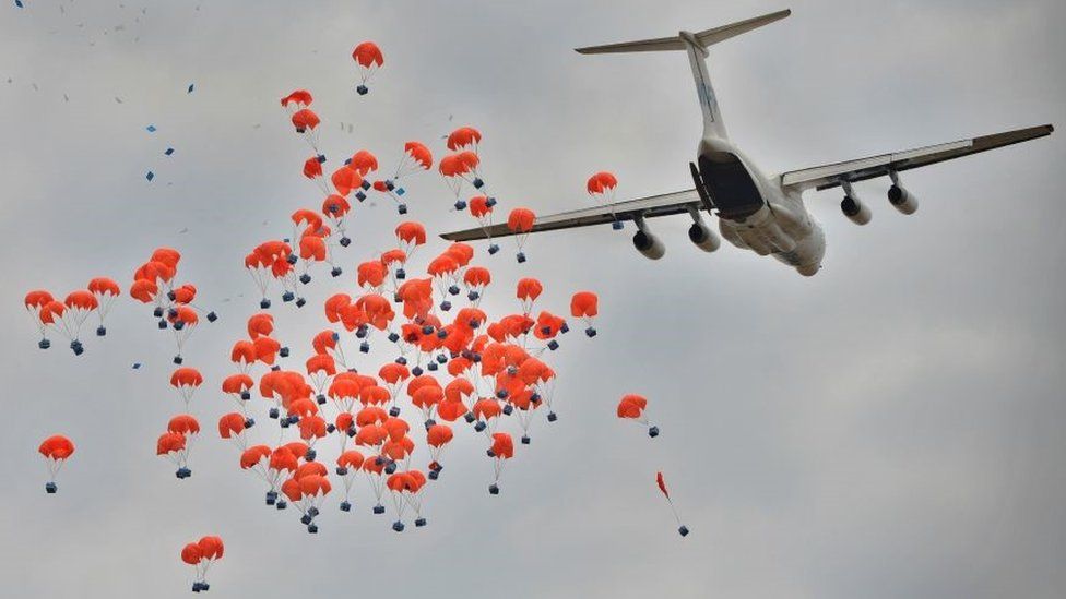 In this file photo taken on February 06, 2020 an Ilyushin aircraft leased to the World Food Programme (WFP) drops food aid parcels near a village in Ayod county, South Sudan