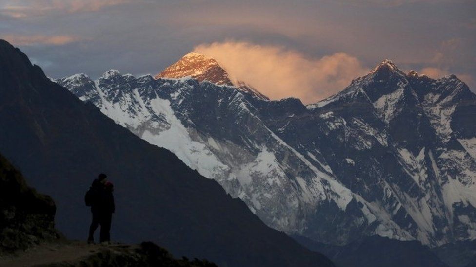 Light illuminates Mount Everest (C) during sunset in Solukhumbu district, also known as the Everest region (November 2015)