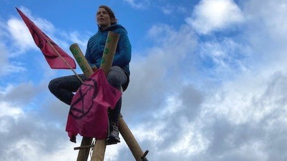 A protester on top of a bamboo structure