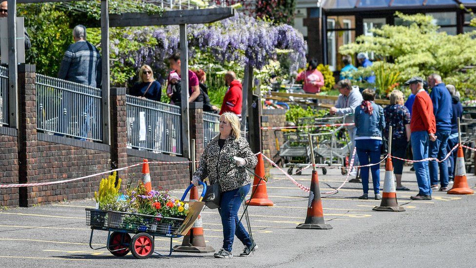 People queue at a garden centre in Caerphilly, Wales, as minor changes to lockdown restriction begin across Wales.