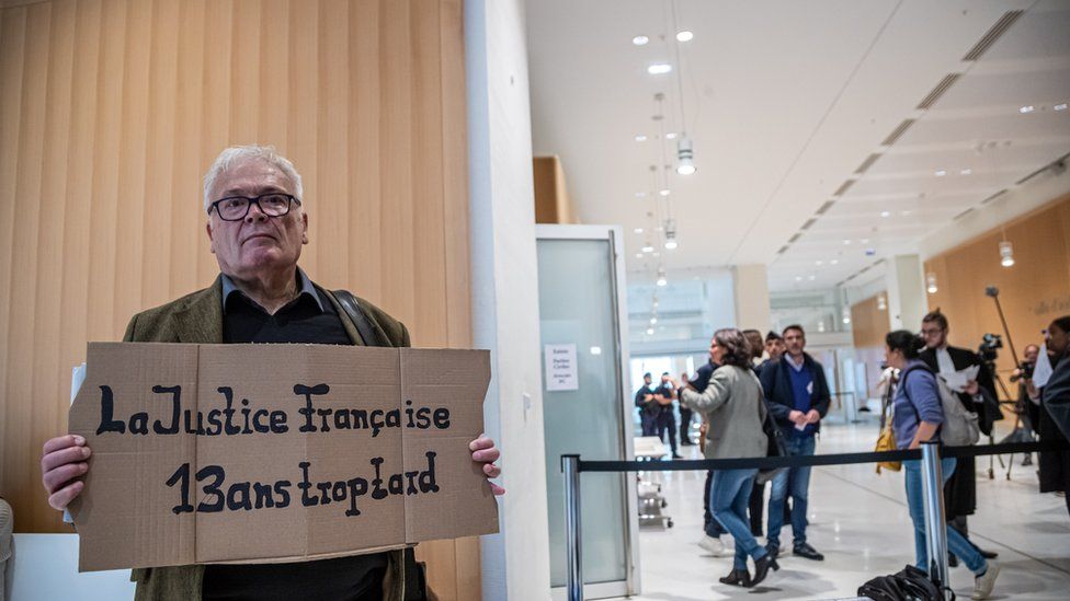 A relative of victims of AF 447 holds a poster reading 'French Justice 13 years too late' on the first day of the trial