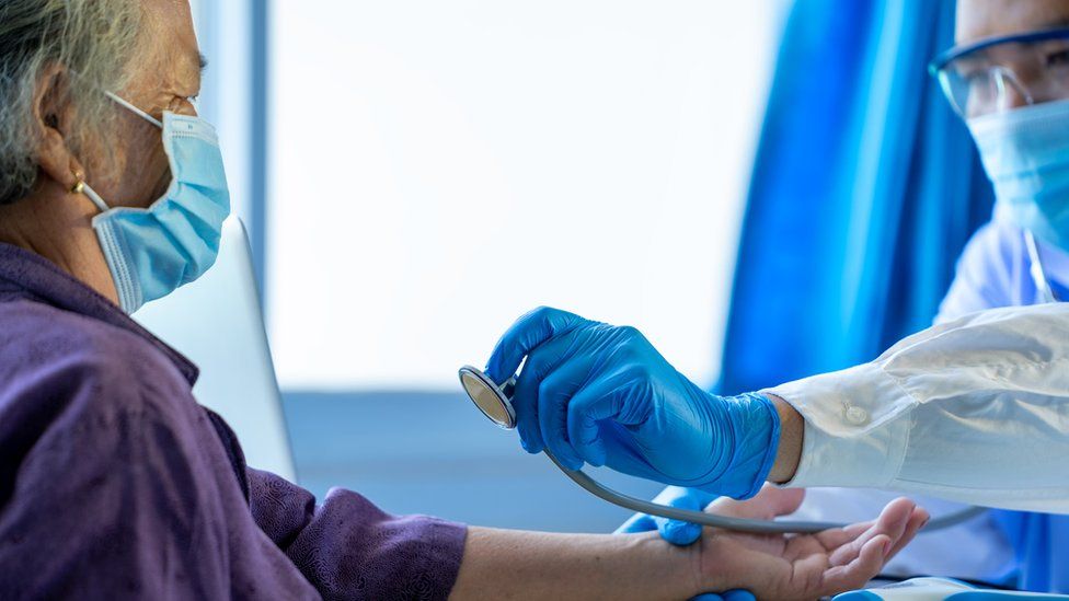 A masked patient seeing a doctor in surgery