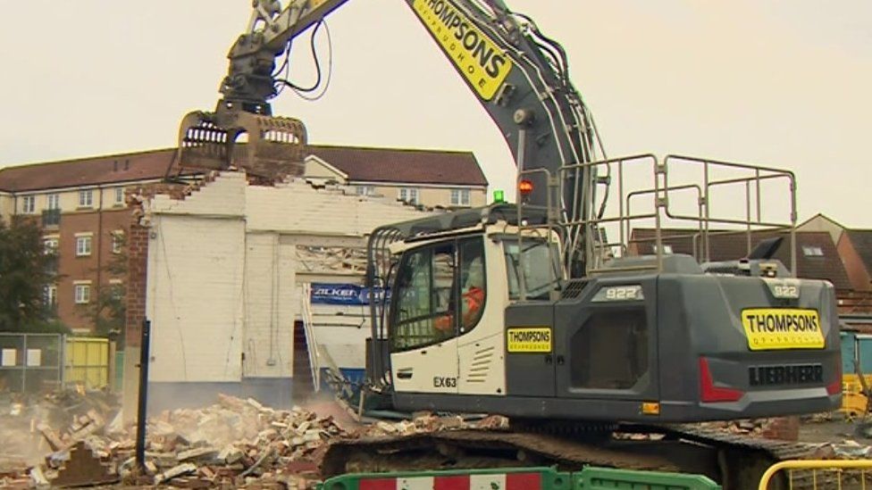 A bulldozer demolishes a building at Darlington station