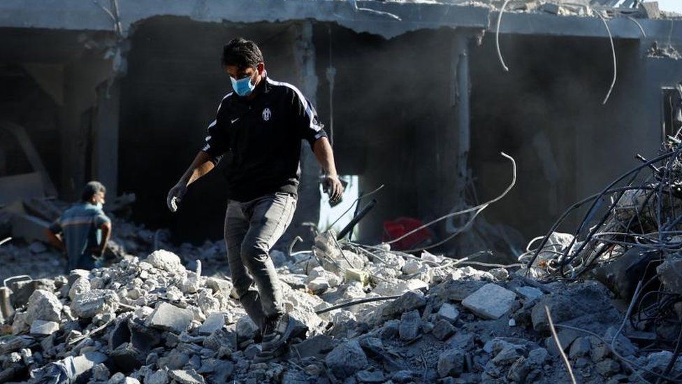A man walks on rubble of destroyed buildings in Gaza