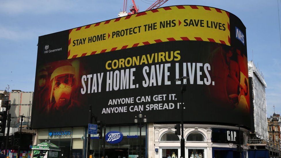 A huge sign displays health advice at Piccadilly Circus in London in April 2020