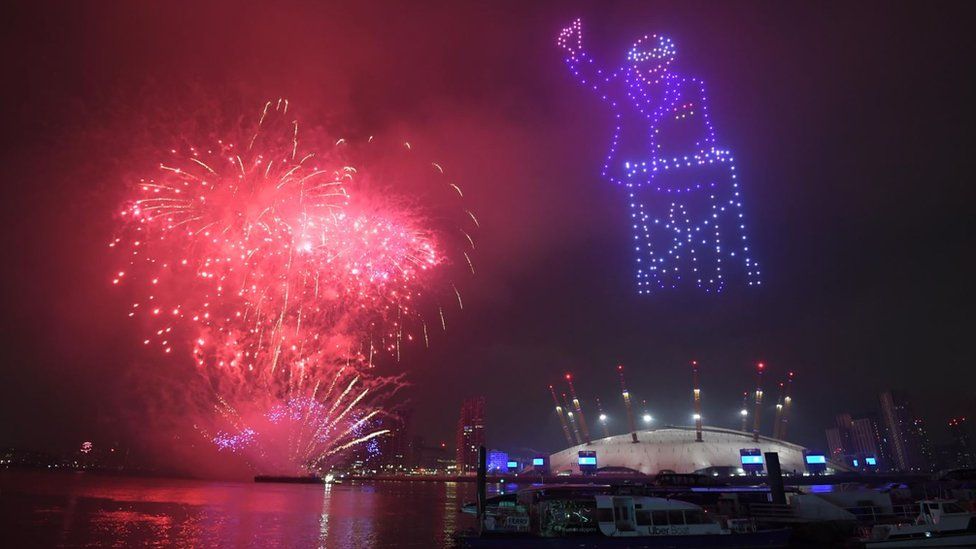 An image of Capt Sir Tom lit up the night sky during the virtual 2021 New Year celebrations over the Millennium Dome (O2 Arena) in London