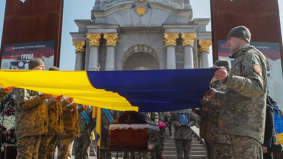 Украински военнослужещи държат национален флаг над ковчега по време на погребалната церемония за украинския военнослужещ Бижан Шаропов в Киев, Украйна, 20 март 2023 г.