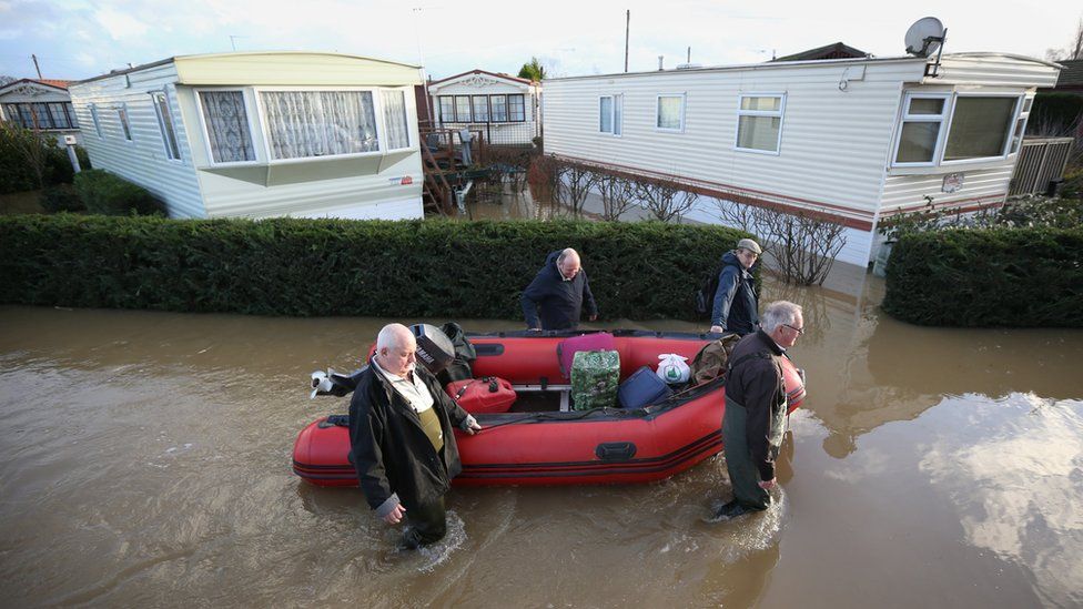 Residents use a boat to rescue possessions from flooded caravans at the Little Venice Country Park on January 2, 2014 in Yalding