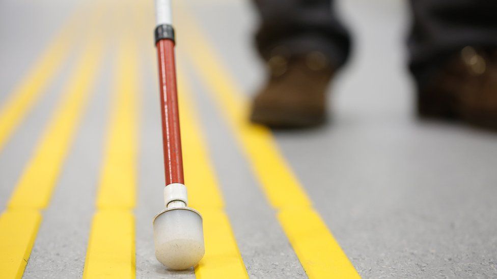 Close-up of blind person's can on road