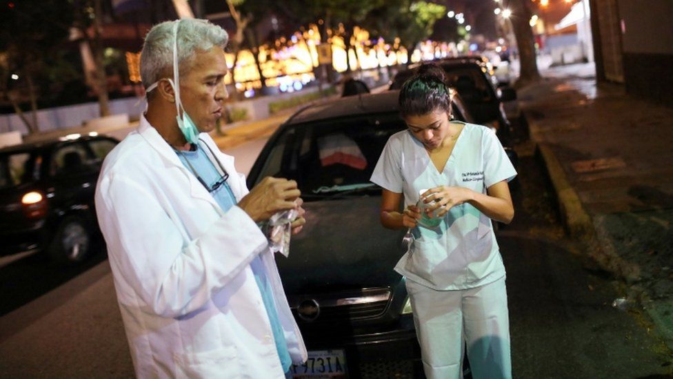 Doctors Carlos Martinez and Maria Martinez eat a snack while they wait in line to get fuel at a gas station, during a nationwide quarantine due to the coronavirus disease (COVID-19) outbreak, in Caracas, Venezuela April 7, 2020.