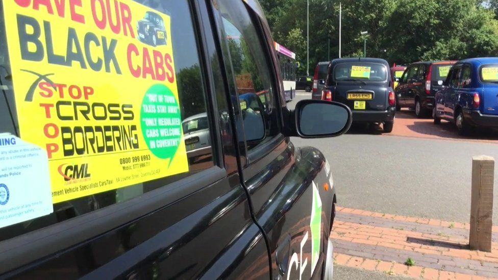 A black cab with a protest sticker on the window