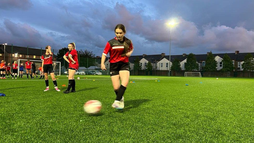 Girls practise their skills on the pitch