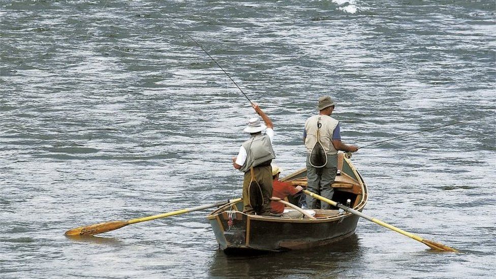 Two fly fishermen and an oarsman on the Yellowstone River near Pine Creek, Montana.