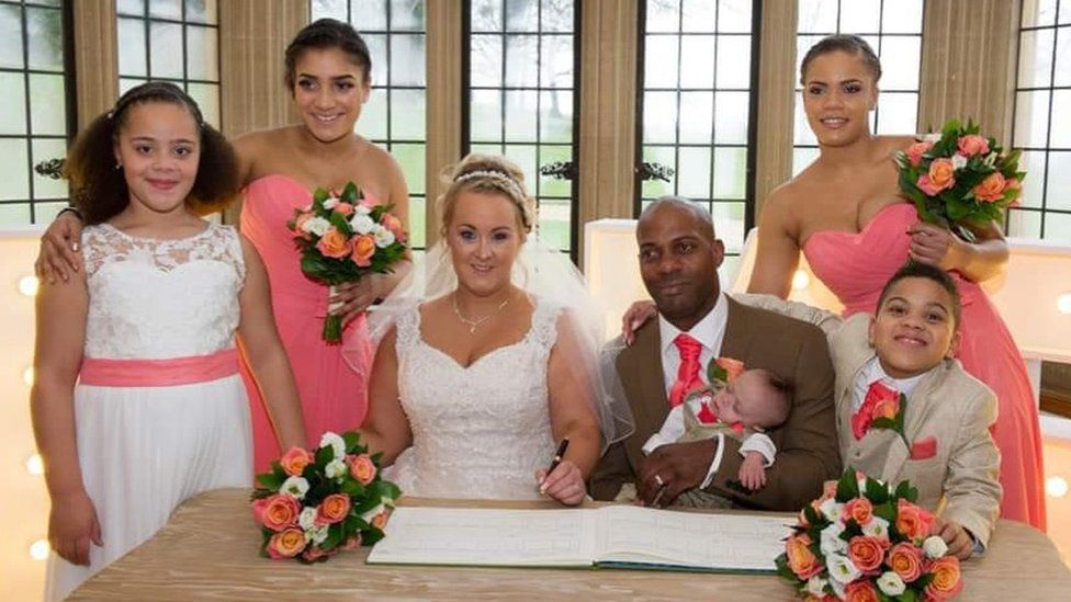 Kassie and Chris Carlyle on their wedding day with their children and bridesmaids