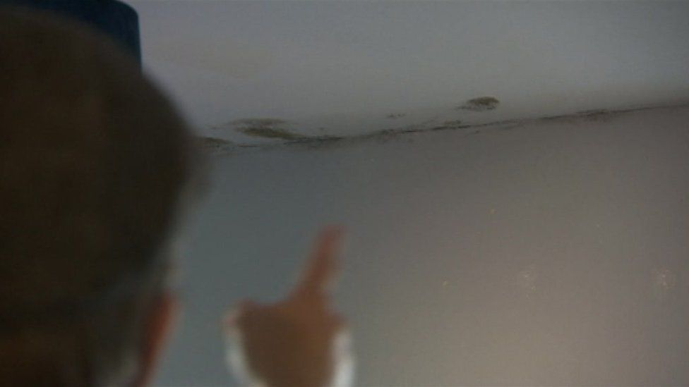 Phil White pointing to some mould on his ceiling