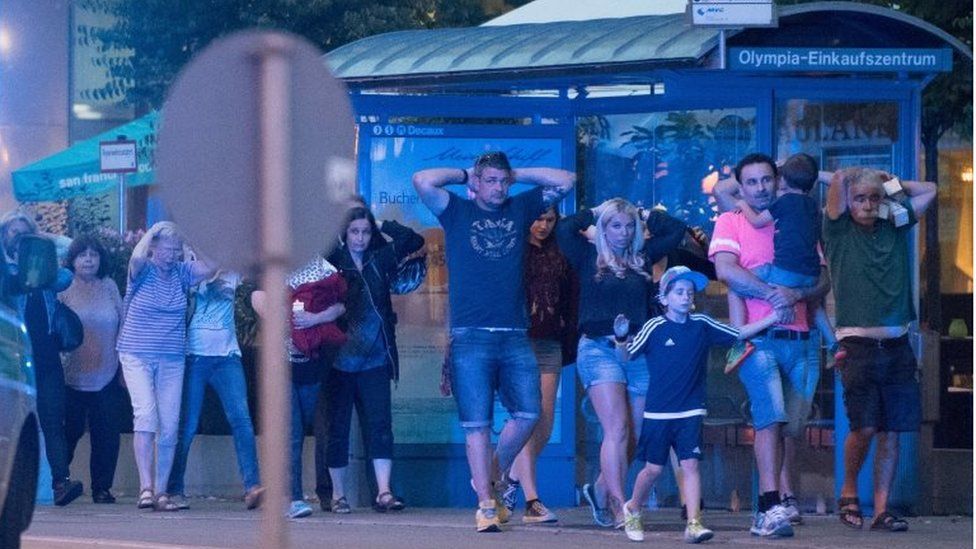 People hurrying from the shopping centre where the shooting took place in Munich, 22 July 2016