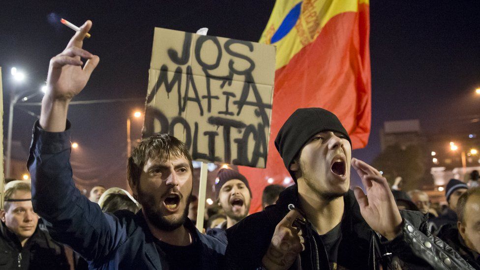 Protesters hold a banner that reads: "Down with the political mafia" at a rally in University Square, Bucharest, Romania. 4 Nov 2015