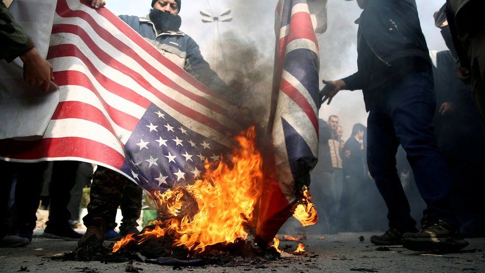 People burn US and British flags at a protest in Tehran, Iran, after the killing of Qasem Soleimani (4 January 2020)