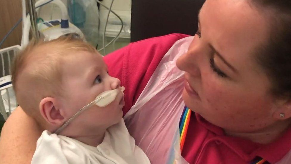 Woman cuddling a baby in hospital