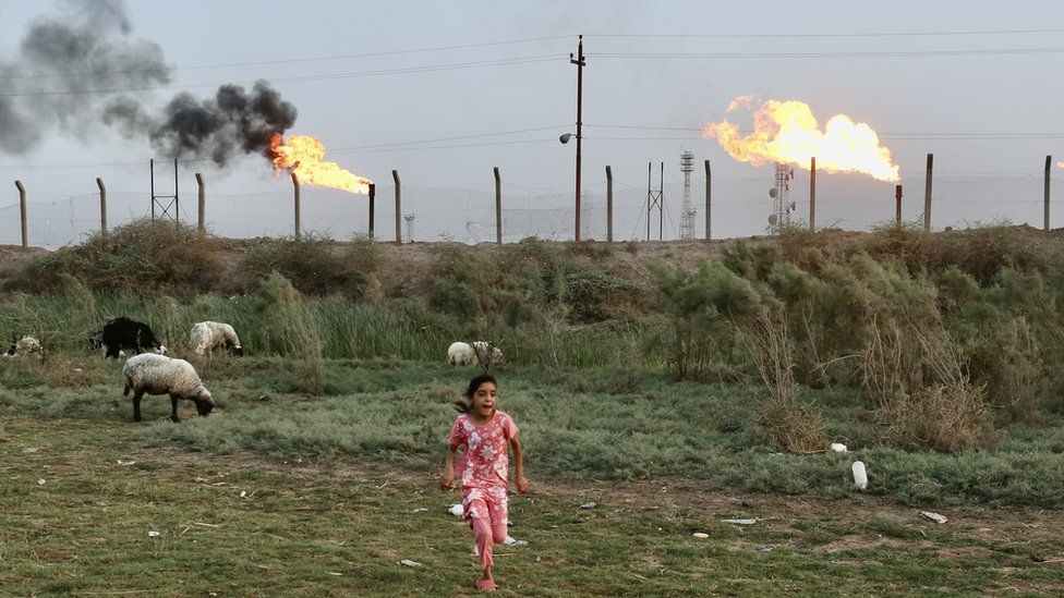 Girl running in front of flares in Nahran Omar
