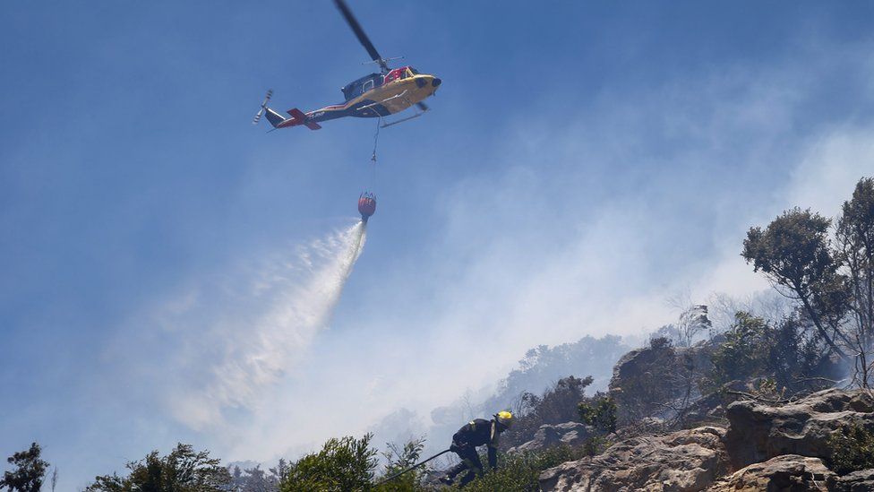 Firefighters battle to contain a bush fire above the mountainous suburb of Capri, Cape Town, South Africa, 24 November 2015.