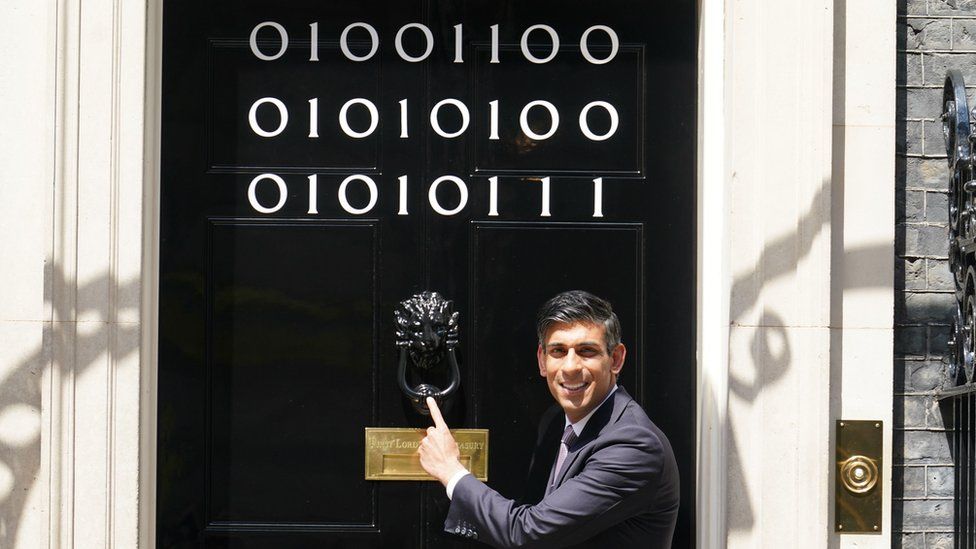 Prime Minister Rishi Sunak at the door of 10 Downing Street decorated with binary code to mark London Tech week in June