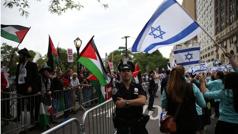 Pro-Israel and Pro-Palestine protesters waving respective country flags