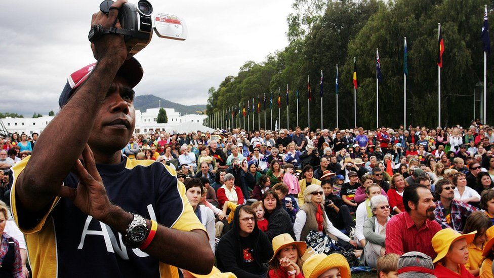Thousands of people gather outside Australia's parliament in 2008 to hear a historic apology to the Stolen Generations