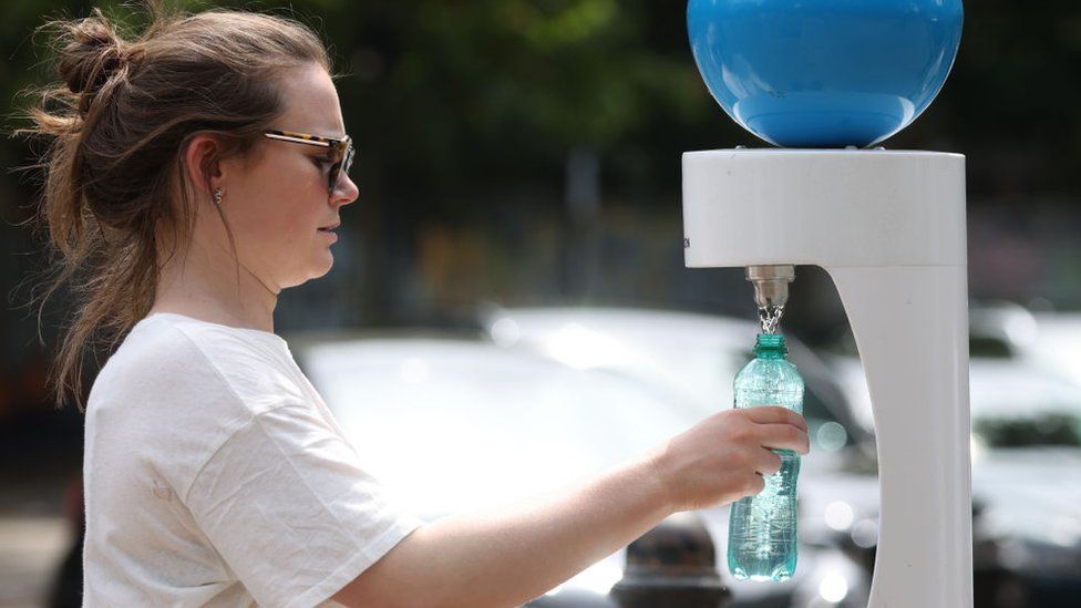 Woman fills a water bottle