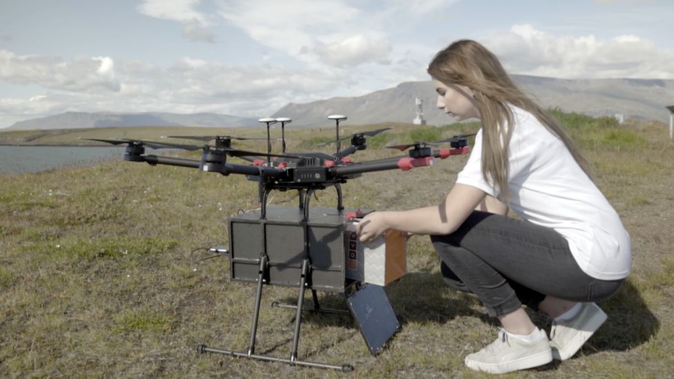 A woman loads sushi into a drone