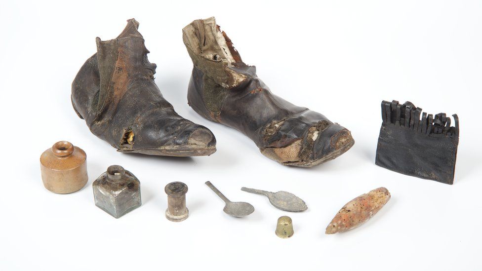 Pair of woman's black leather and patent leather elastic sided boots. 1860-80. Found in Brackley, when repairing the floor in servants quarters at a house. Also found with leather purse, two broken teaspoons, glass bottle, cotton reel and a child's tippet