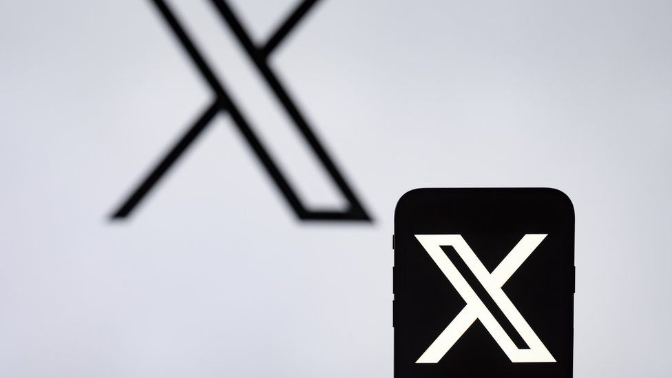 The X logo on a phone screen and in the background
