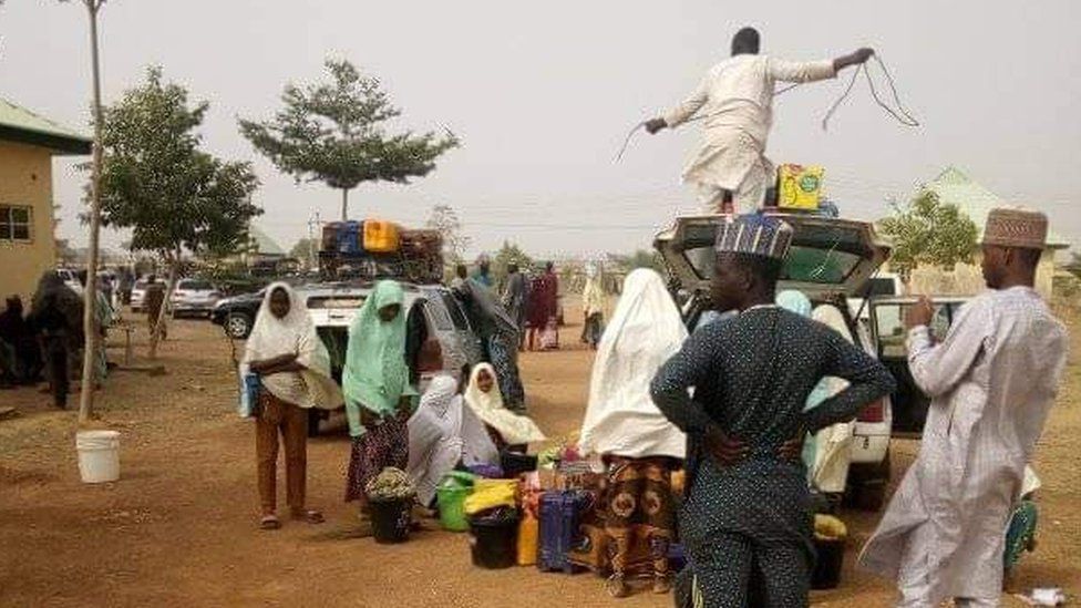 People outside the school, preparing to go home