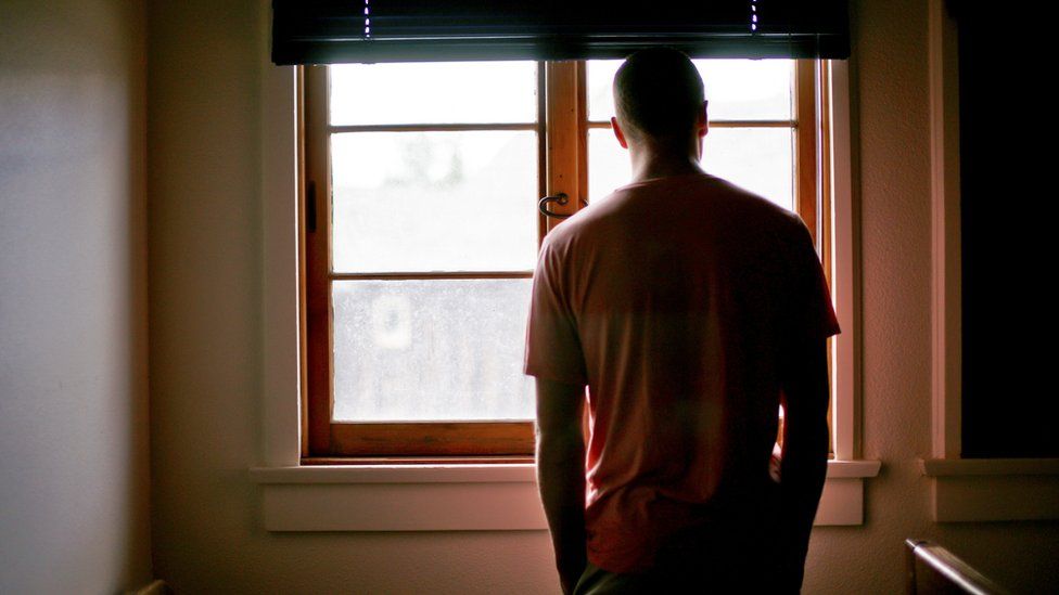 Stock image of a man looking out of the window