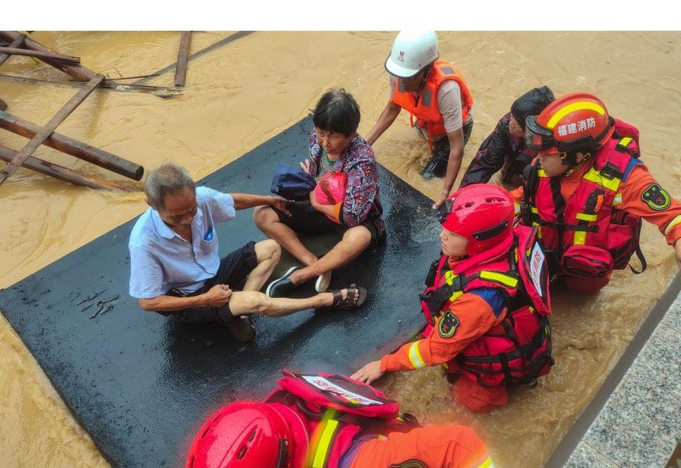 Rescuers evacuate residents in a flooded area after Typhoon Doksuri landfall in Quanzhou, in China's eastern Fujian province on July 28, 2023.