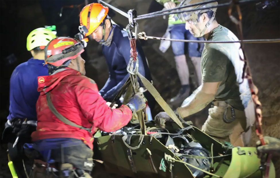 Boy being moved by rescuers inside the cave