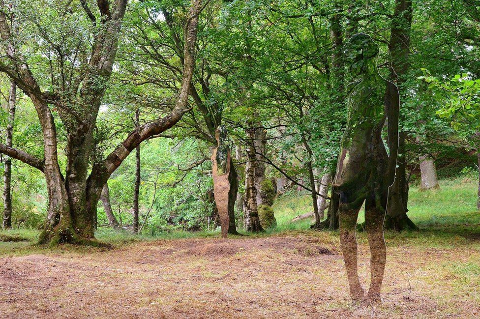 Sculptures standing in woodland