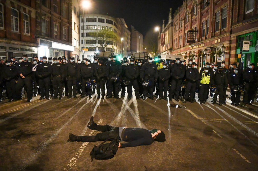 A protester lies in the road in front of a police line during a Kill The Bill demonstration on 3 April 2021 in Bristol, England.